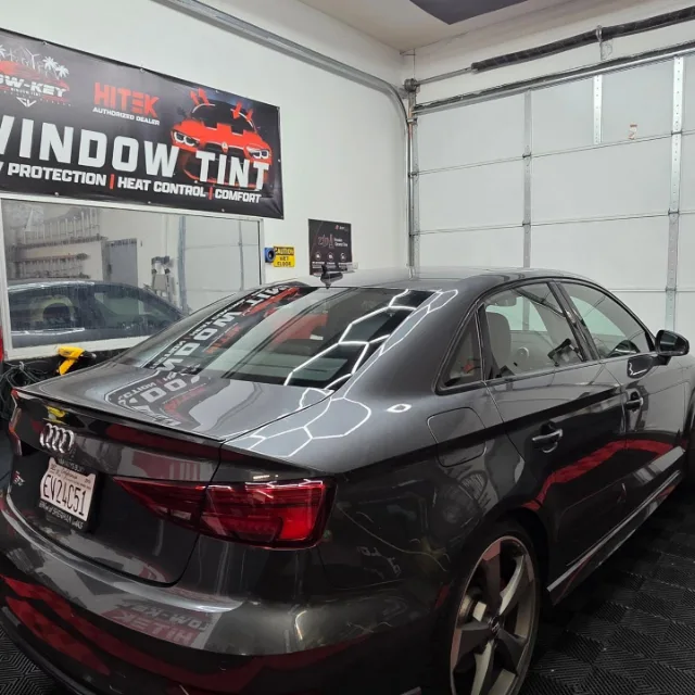 Dark gray Audi S3 viewed from the rear passenger side inside the Lowkey shop